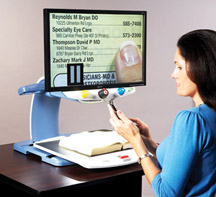 A woman dials a phone while, a Freeze frame on the TOPAZ monitor keeps a phone number magnified and pointed out