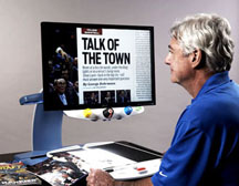 A man magnifies a page in a sports magazine